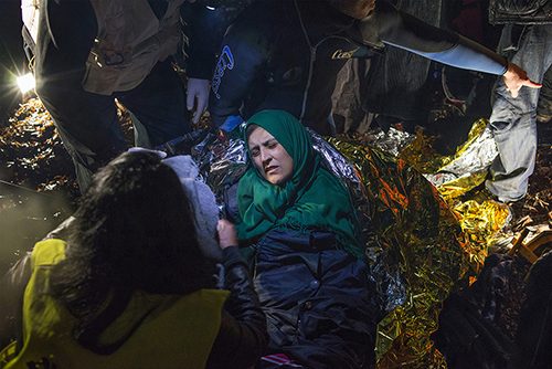 Rescue workers try to warm a Syrian woman suffering from severe hypothermia after a boat landing on Lesbos. Some of the refugees had spent up to six hours on the sea at night, hoping to get by the Turkish coastguard, which would return them to Turkey according to a deal struck with the EU. March 20, 2016
