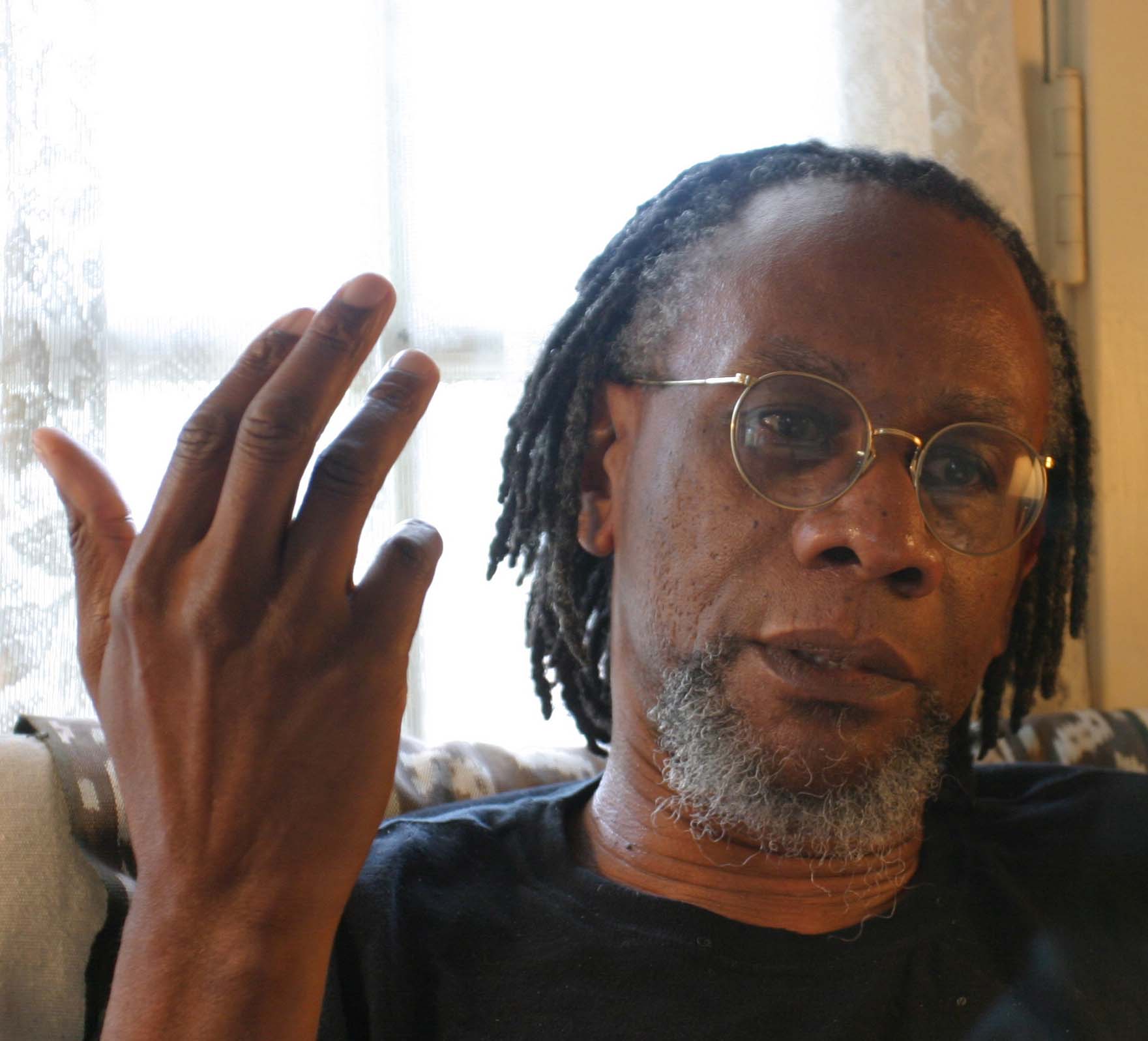 Poet Nathaniel Mackey during an interview, seated on a couch.