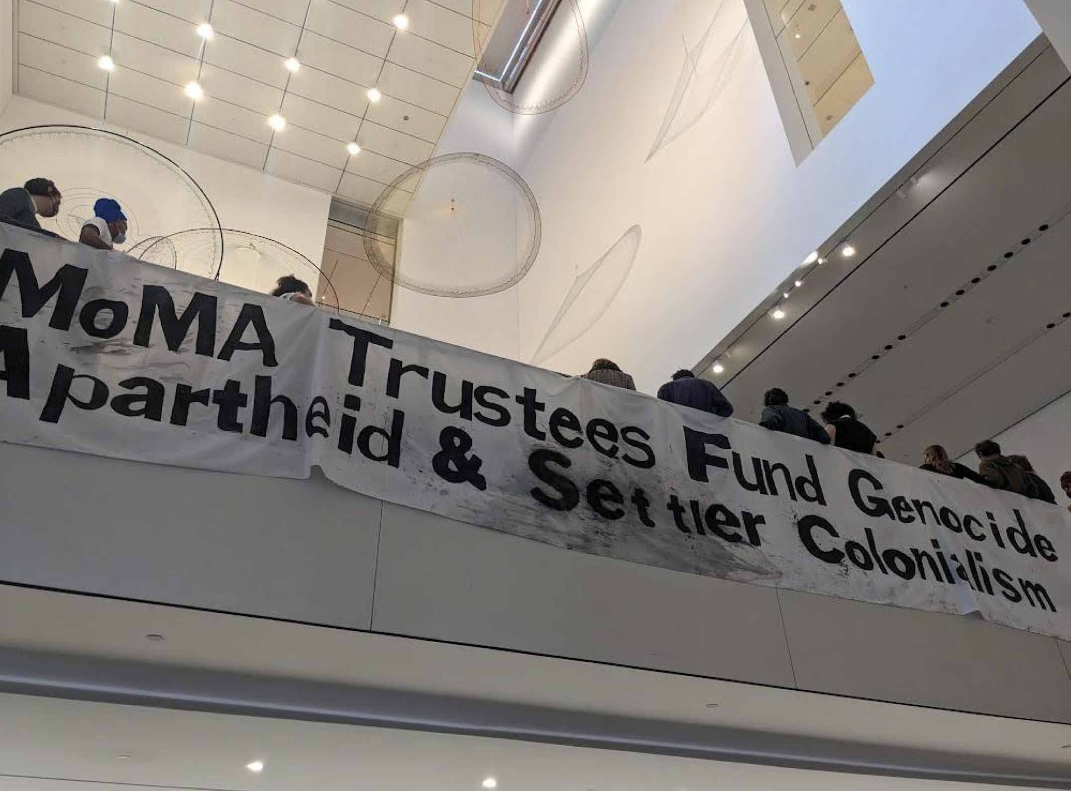 Banner unfurled at the MoMA by peaceful protestors and art-industry workers, February 10, 2024 – Photo Ocean DeRouchie