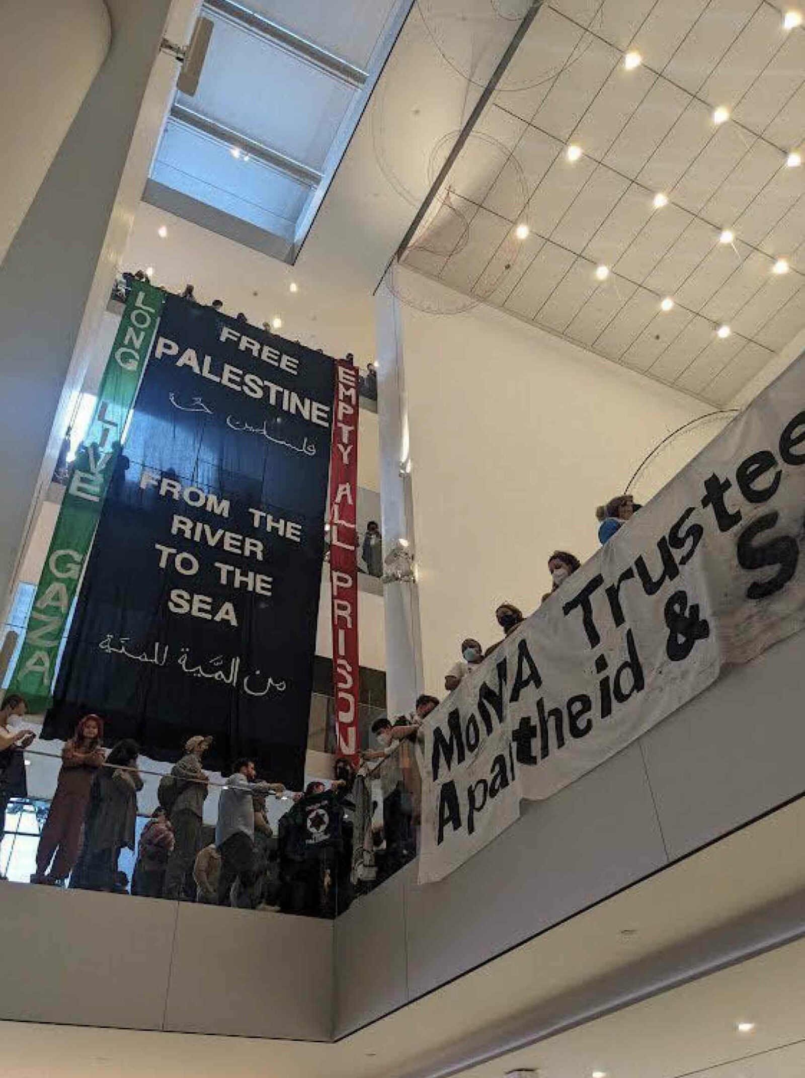 Artists and their banners in support of Palestine, demanding “the immediate removal of board members with direct ties to genocide, apartheid and settler colonialism.”